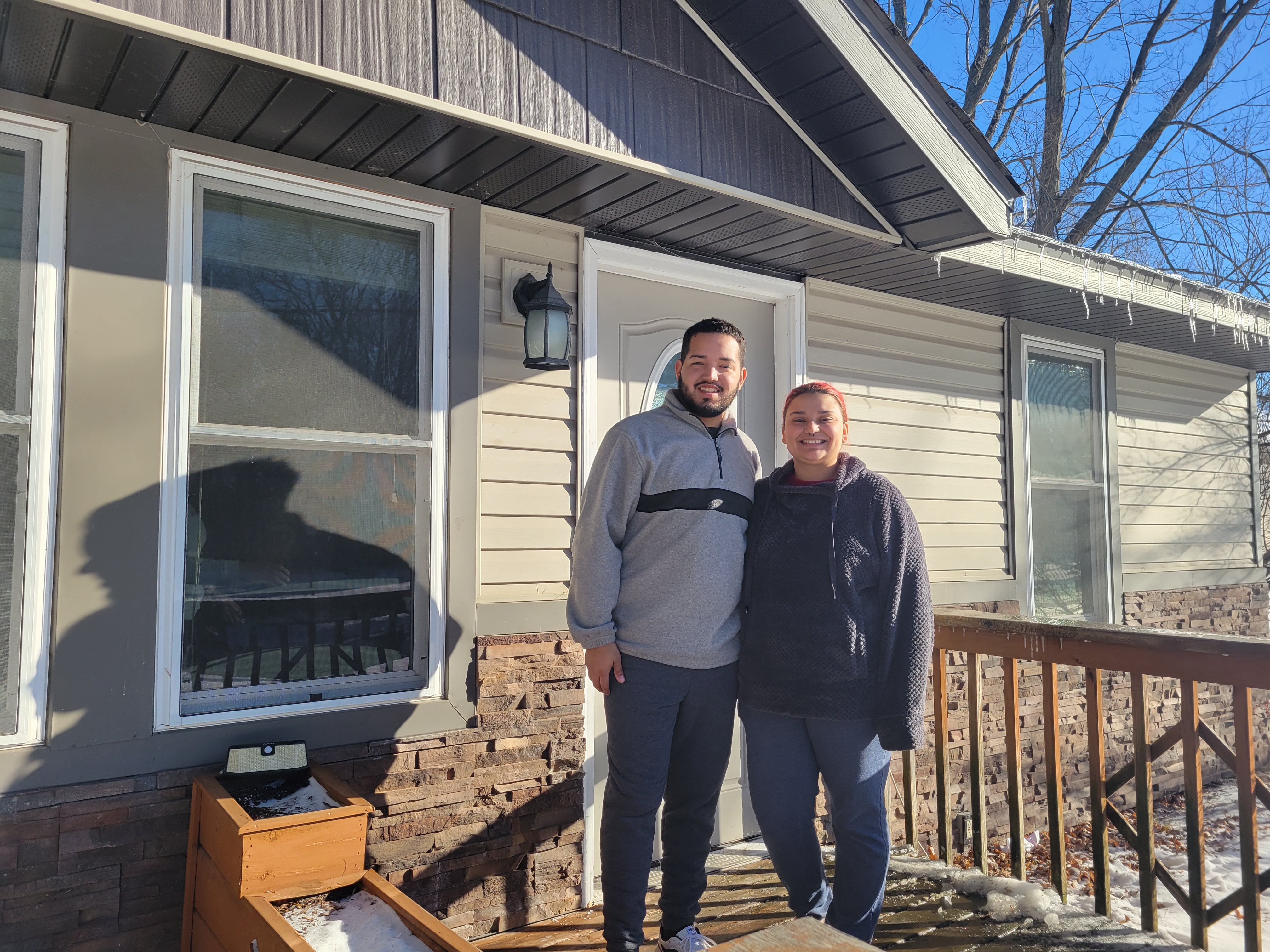 Homeowners in front of house