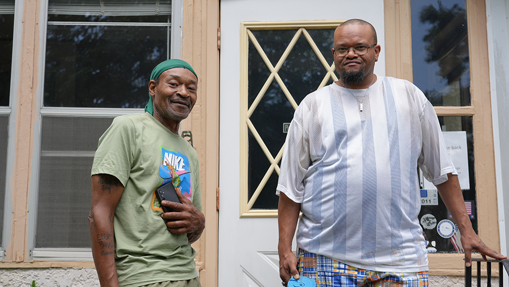 Homebuyer_and_family_member_standing_in_front_of_house